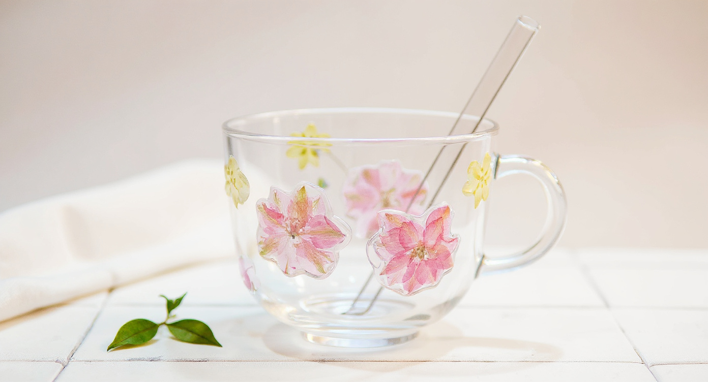 Handcrafted Floral Glass Cup with Real Preserved Flowers, glass lid and straw on blush linen flat lay