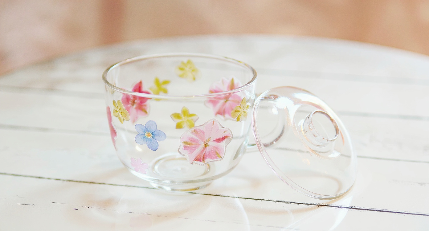 Handcrafted Floral Glass Cup with Real Preserved Flowers beside pampas stems and linen napkin.