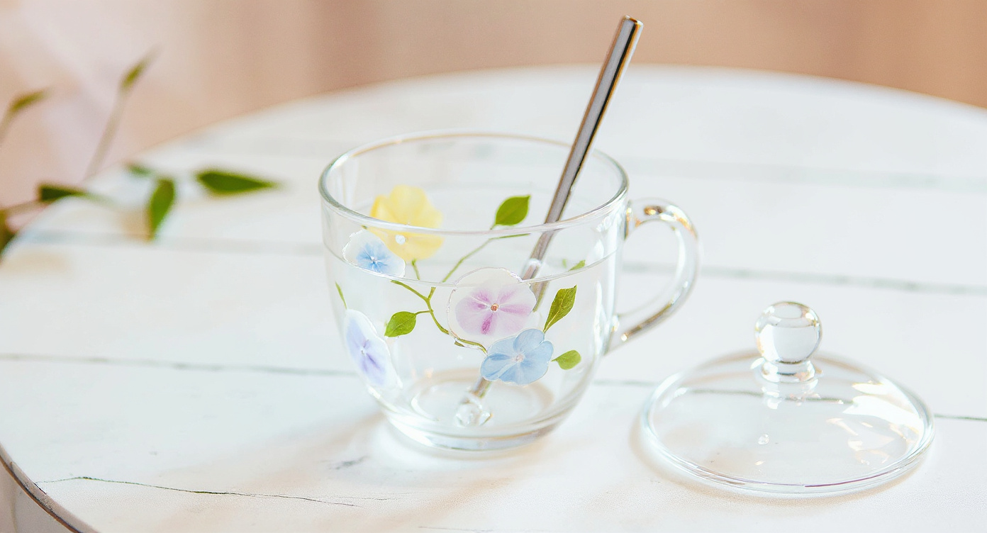 Close-up of Handcrafted Floral Glass Cup with Real Preserved Flowers raised floral relief texture.