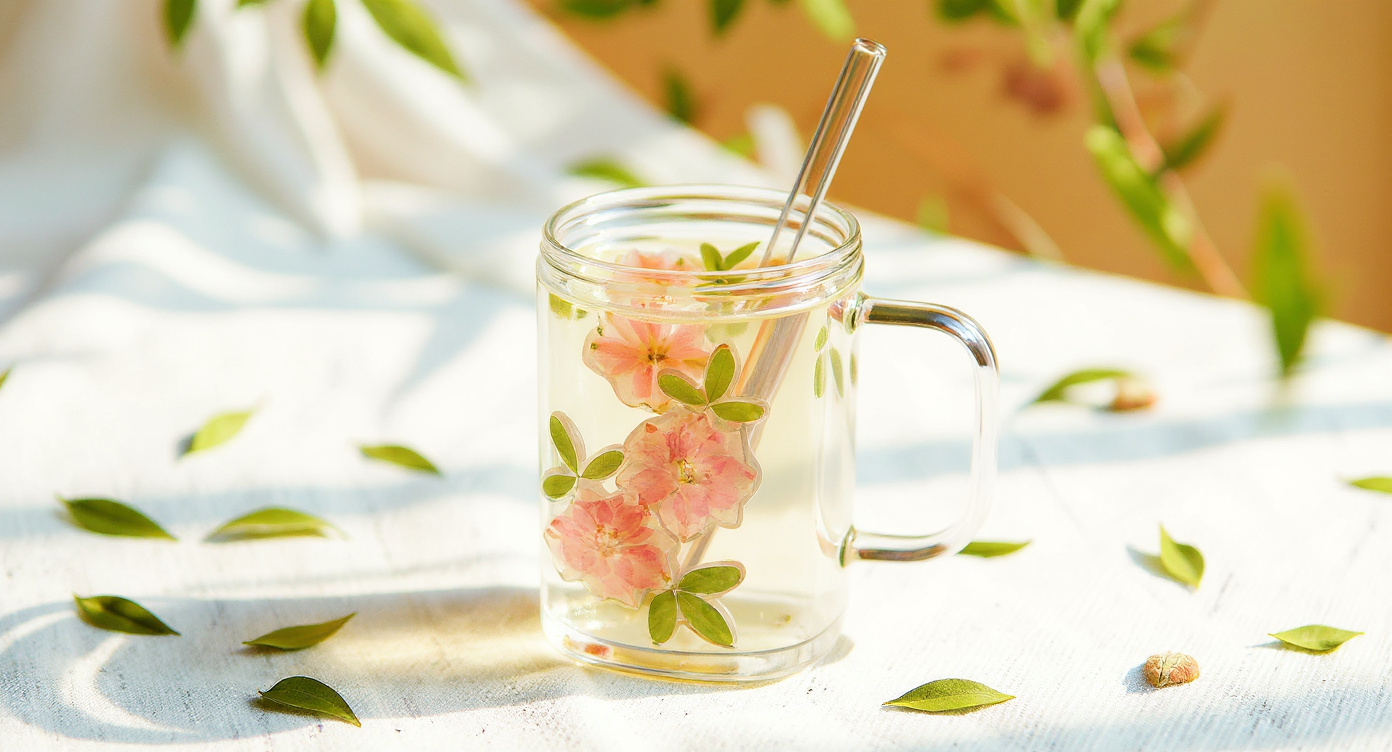 Close-up of Handcrafted Preserved Flower Glass Cup with embedded petals on linen